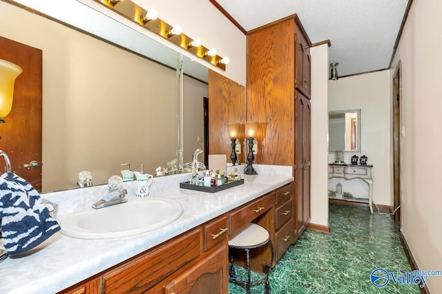 bathroom featuring vanity, ornamental molding, and a textured ceiling