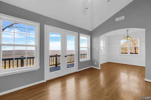 interior space featuring french doors, wood-type flooring, a chandelier, and vaulted ceiling