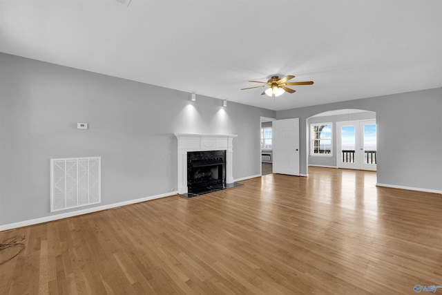 unfurnished living room with ceiling fan, light hardwood / wood-style floors, and a premium fireplace