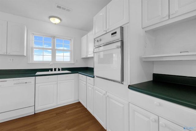 kitchen with white cabinets, white appliances, dark hardwood / wood-style floors, and sink