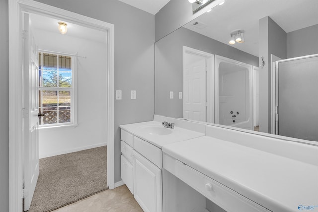 bathroom with a shower with shower door and vanity