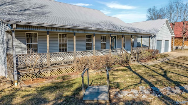 view of front of home featuring a porch, a garage, and a front lawn