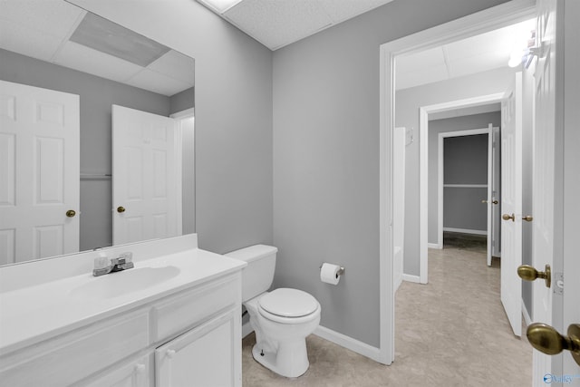 bathroom featuring toilet, a paneled ceiling, and vanity