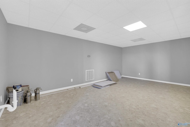 carpeted empty room with a drop ceiling