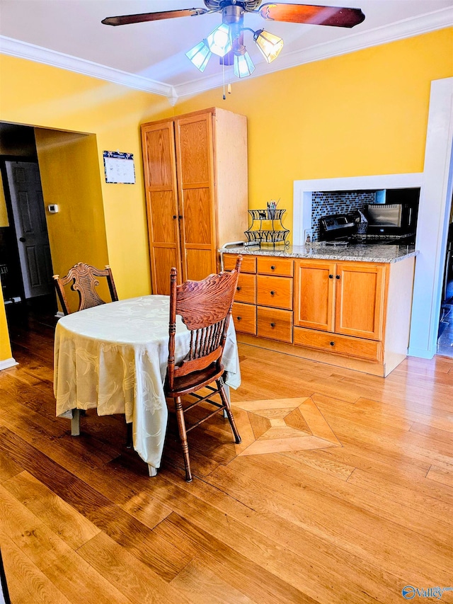 dining space with light hardwood / wood-style flooring, ceiling fan, and crown molding