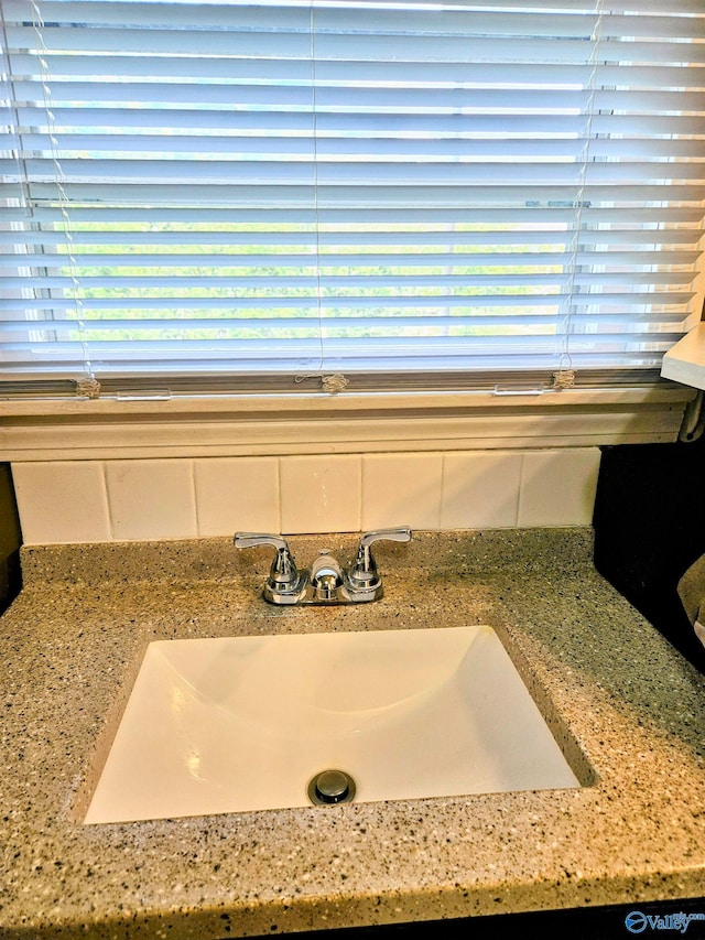 interior details featuring light stone countertops and sink