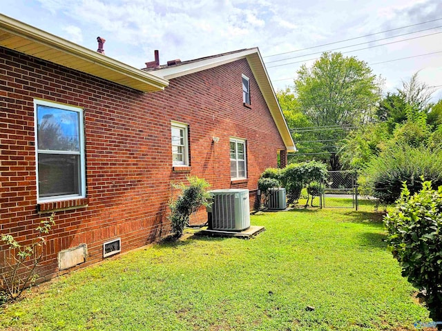 view of side of home with cooling unit and a yard