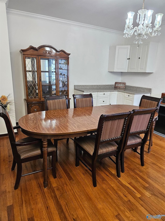 dining room featuring a notable chandelier, hardwood / wood-style flooring, and ornamental molding