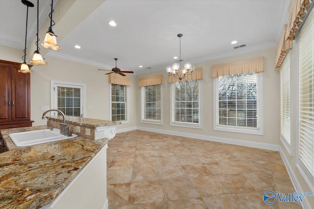 kitchen featuring decorative light fixtures, sink, and crown molding