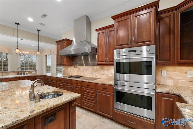 kitchen with light stone counters, sink, stainless steel double oven, and extractor fan