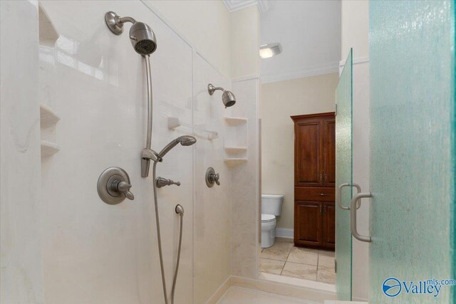 bathroom with toilet, ornamental molding, tile patterned flooring, and a shower with door