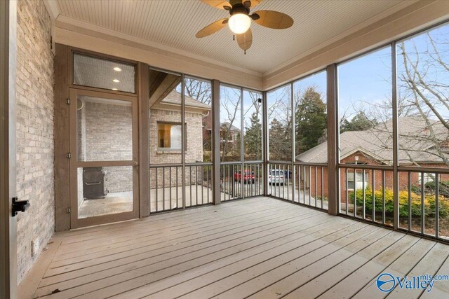 unfurnished sunroom featuring ceiling fan