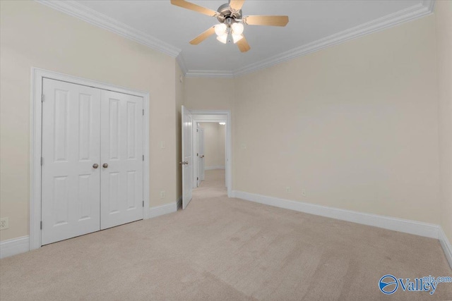 unfurnished bedroom featuring ceiling fan, a closet, light carpet, and ornamental molding