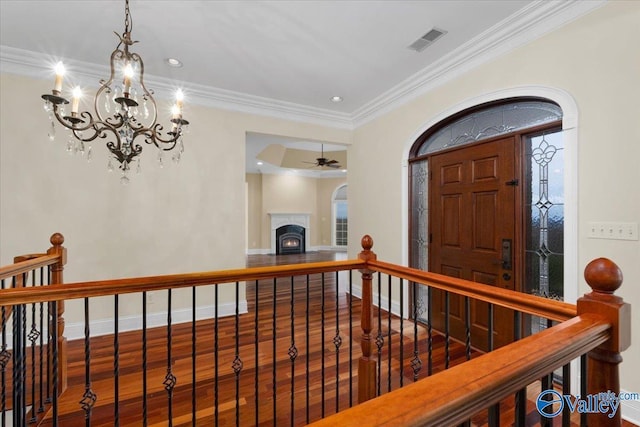 hallway with ornamental molding, hardwood / wood-style floors, and a notable chandelier