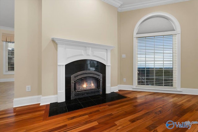 interior details with crown molding, hardwood / wood-style floors, and a tile fireplace