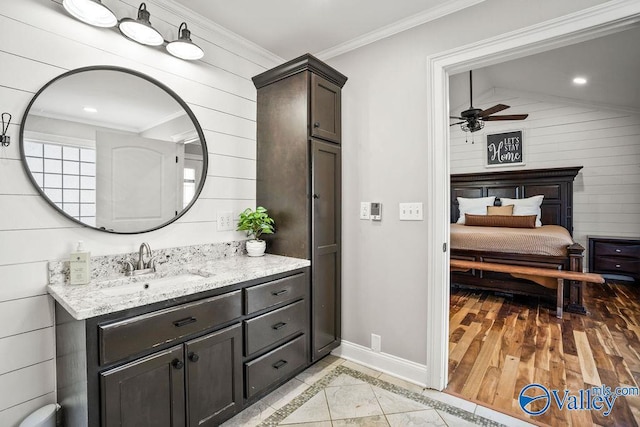 ensuite bathroom with vanity, baseboards, a ceiling fan, ensuite bath, and crown molding