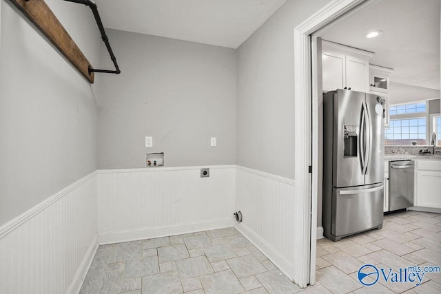 laundry room featuring washer hookup, a wainscoted wall, hookup for an electric dryer, and a sink