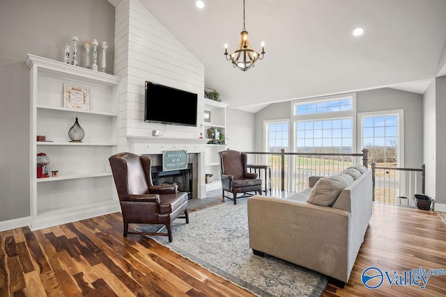 living area featuring baseboards, wood finished floors, an inviting chandelier, a fireplace, and recessed lighting