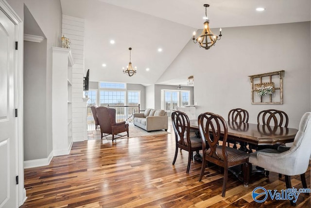 dining area featuring recessed lighting, an inviting chandelier, wood finished floors, high vaulted ceiling, and baseboards