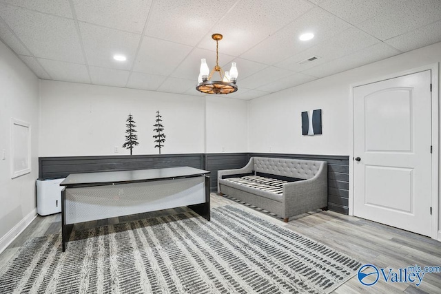 interior space featuring a paneled ceiling, a notable chandelier, visible vents, and wood finished floors