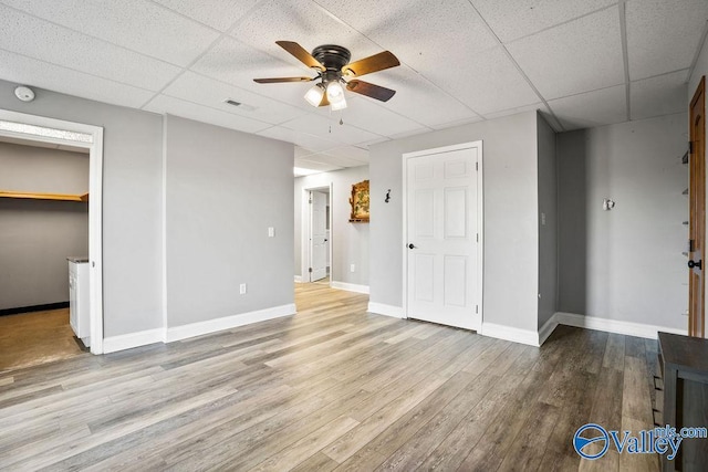 unfurnished bedroom with visible vents, a paneled ceiling, light wood-style flooring, and baseboards