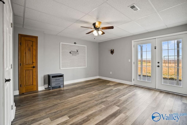 unfurnished room featuring a drop ceiling, wood finished floors, visible vents, baseboards, and french doors