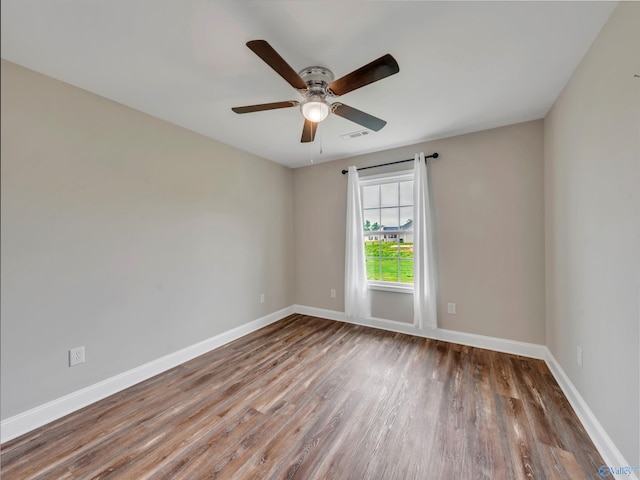 empty room with baseboards, a ceiling fan, and wood finished floors