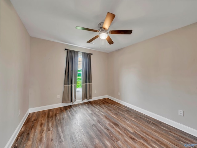 empty room with baseboards, ceiling fan, and wood finished floors