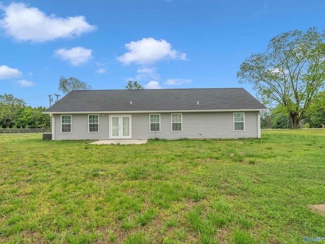 back of property with a lawn, a patio area, fence, and french doors