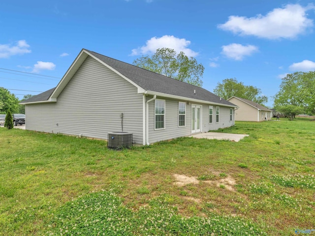 rear view of house with a lawn, central AC, and a patio area
