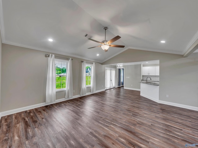 unfurnished living room with crown molding, dark wood-style flooring, ceiling fan, baseboards, and vaulted ceiling