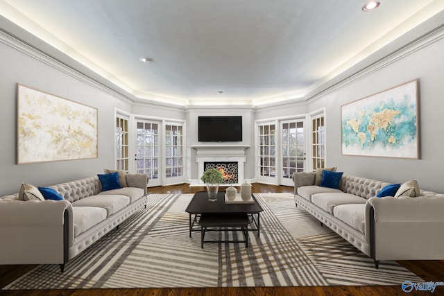 living area with a lit fireplace, wood finished floors, and recessed lighting