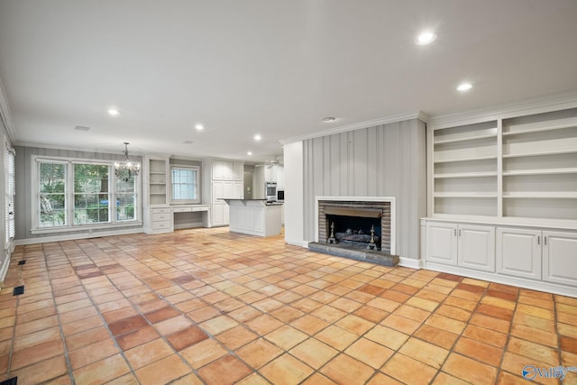 unfurnished living room featuring a fireplace, built in features, and crown molding