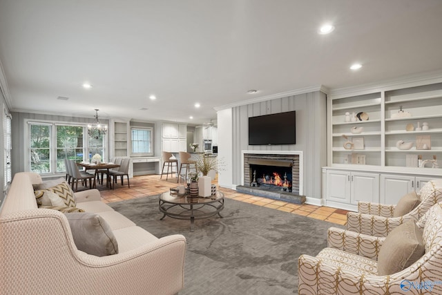 living room featuring light tile patterned floors, a fireplace, built in shelves, and crown molding