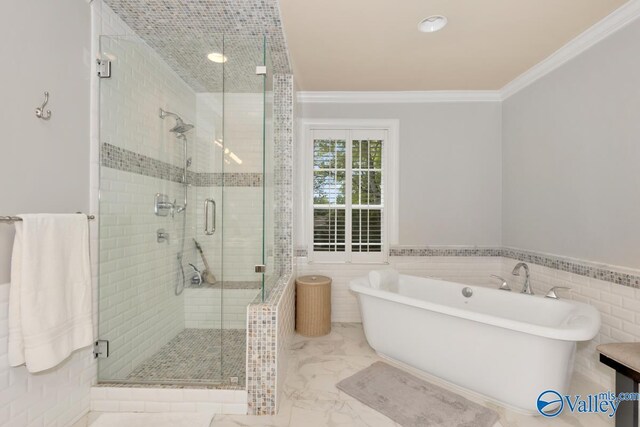 full bath with tile walls, marble finish floor, ornamental molding, a soaking tub, and a shower stall