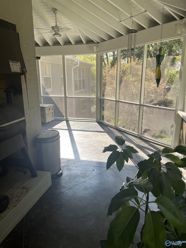 sunroom / solarium with vaulted ceiling with beams and a ceiling fan