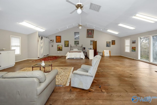 living room featuring lofted ceiling, plenty of natural light, visible vents, and wood finished floors