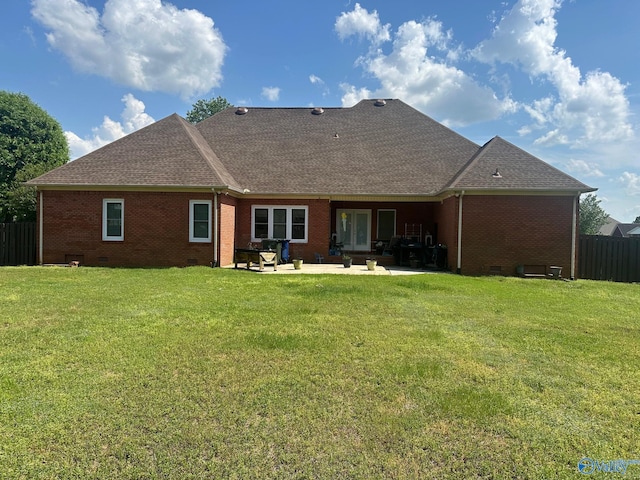 rear view of house with a patio, roof with shingles, fence, and brick siding