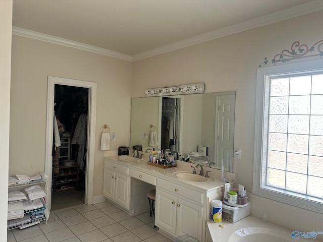 bathroom featuring a walk in closet, tile patterned floors, ornamental molding, and a sink