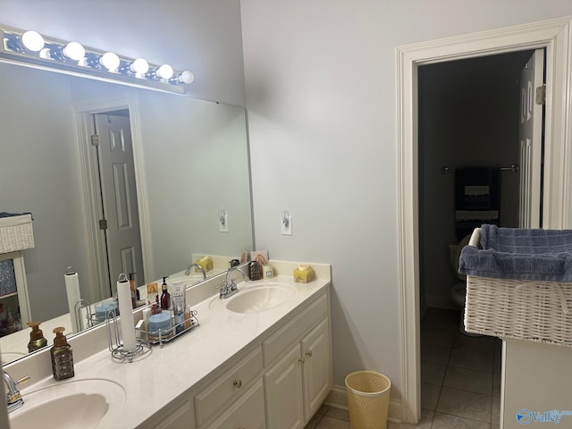 bathroom with double vanity, a sink, baseboards, and tile patterned floors