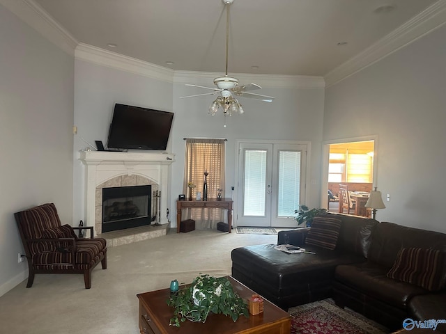 carpeted living area featuring ornamental molding, a fireplace, a ceiling fan, and a high ceiling