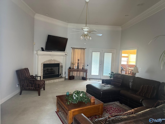 living room with ceiling fan, a high ceiling, light carpet, a fireplace, and ornamental molding