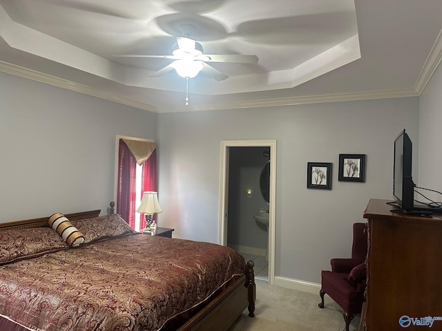 bedroom with baseboards, ornamental molding, light carpet, and a tray ceiling