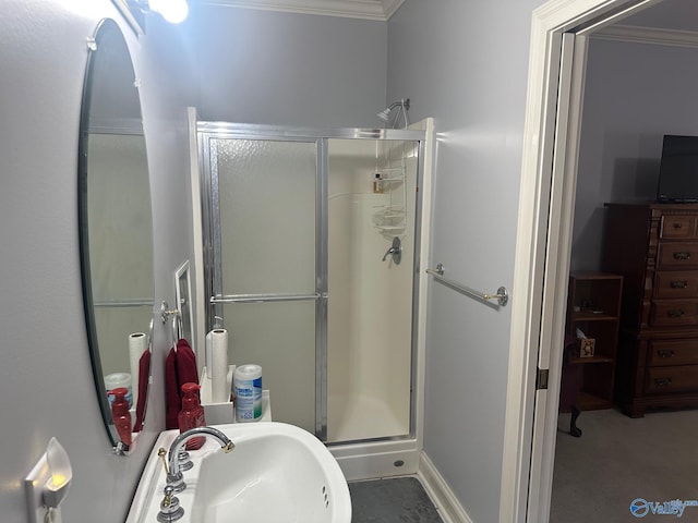 full bathroom with a sink, ornamental molding, and a shower stall