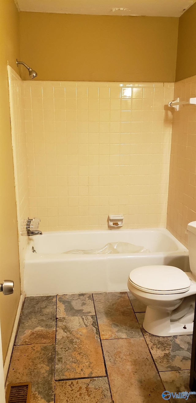 bathroom with tiled shower / bath and toilet