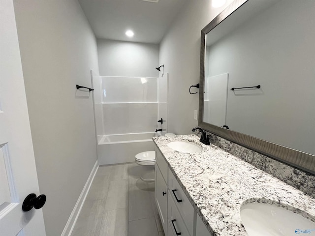 bathroom featuring double vanity,  shower combination, a sink, and toilet