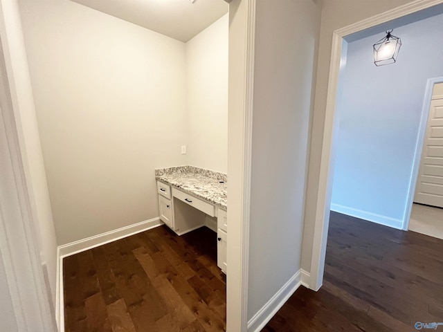 hall featuring baseboards and dark wood-style flooring