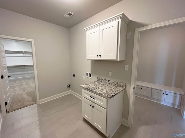 clothes washing area with cabinet space, visible vents, baseboards, hookup for an electric dryer, and washer hookup