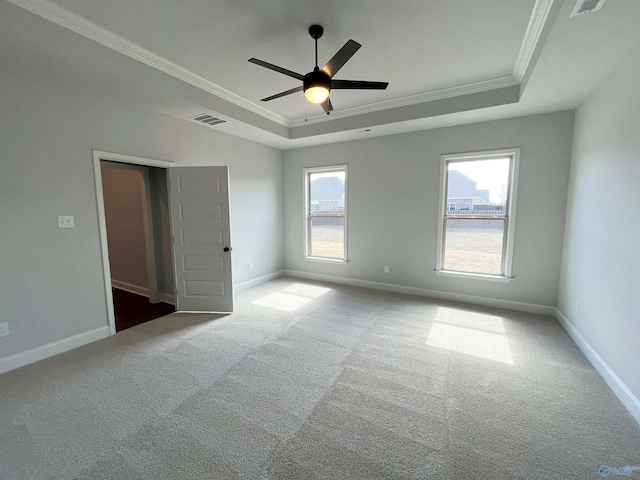 unfurnished bedroom with ornamental molding, a raised ceiling, visible vents, and baseboards