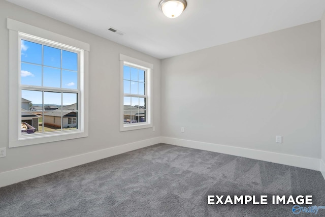 carpeted spare room featuring visible vents and baseboards